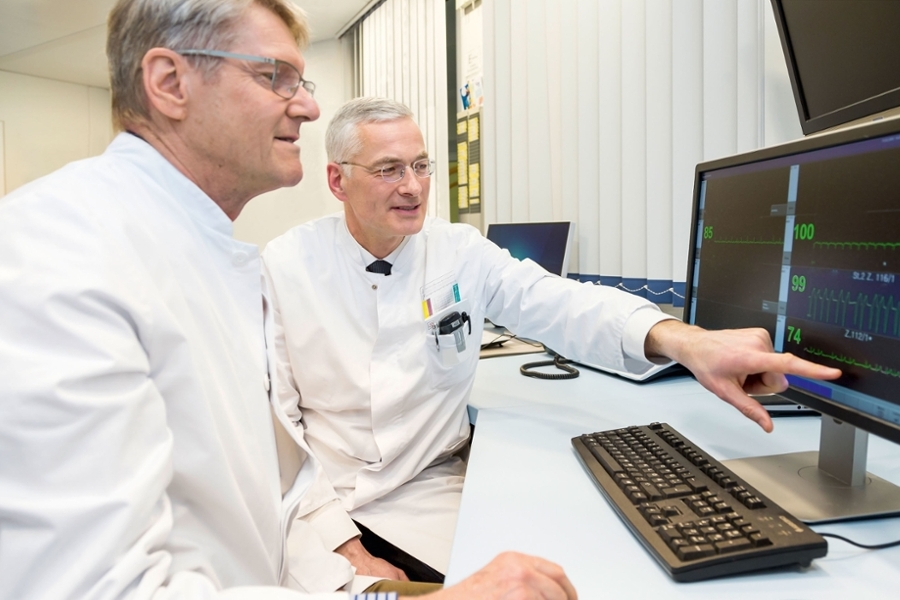 Zwei Ärzte sitzen vor einem PC und werten Ergebnisse aus. Zwei Ärzte sitzen vor einem PC und werten Ergebnisse aus.